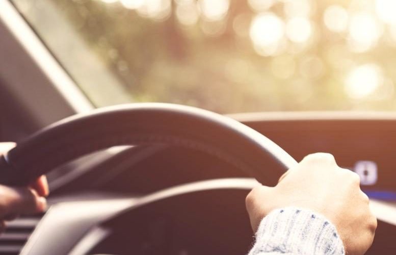 Person with two hands on steering wheel