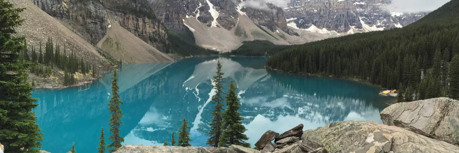 Scenic photo of lake with mountains in the background