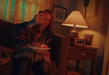 Man on couch eating fries
