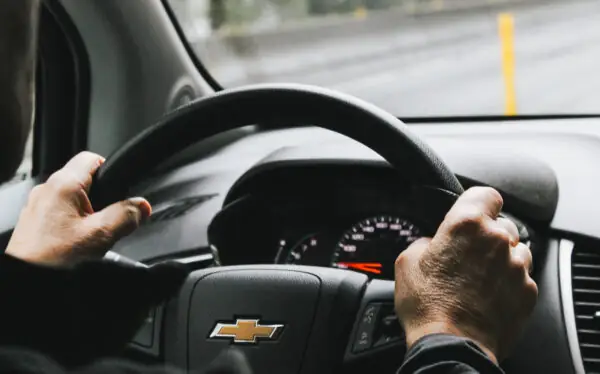 Man in car with hand on steering wheel